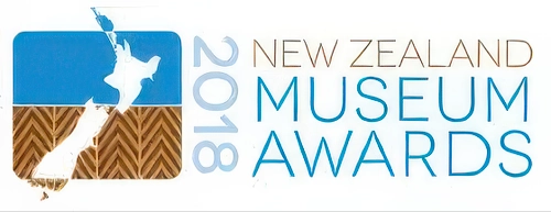 New Zealand Museum Awards 2018 logo featuring a stylized map of New Zealand in white on blue background with brown woven pattern below, accompanied by blue text on right side.