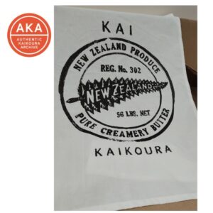 Vintage New Zealand butter packaging label from Kaikōura, featuring a fern leaf design and 'Pure Creamery Butter' text, displayed at Kaikōura Museum. AKA archive logo visible in top left corner.